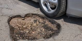 A deep rut, or widened gap in asphalt, known as a pothole.