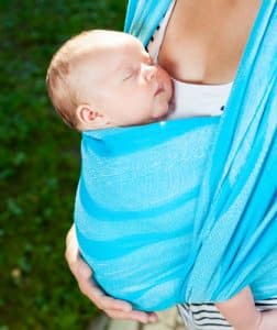 Mother carrying her child in a baby sling
