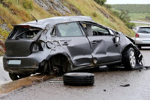 Image of a silver prius with severe crash damage to the right front and rear panels, and rear end damage. Malibuu Canyon landslide accident circa 2016.