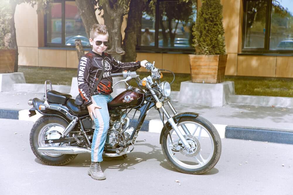 kid riding motorcycle with dad