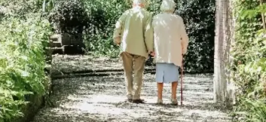 Two seniors with a walking cane