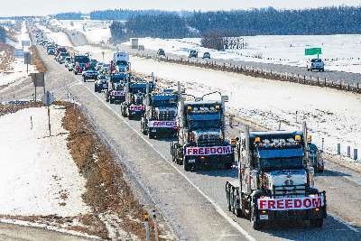 Convoy of big rig trucks in the snow