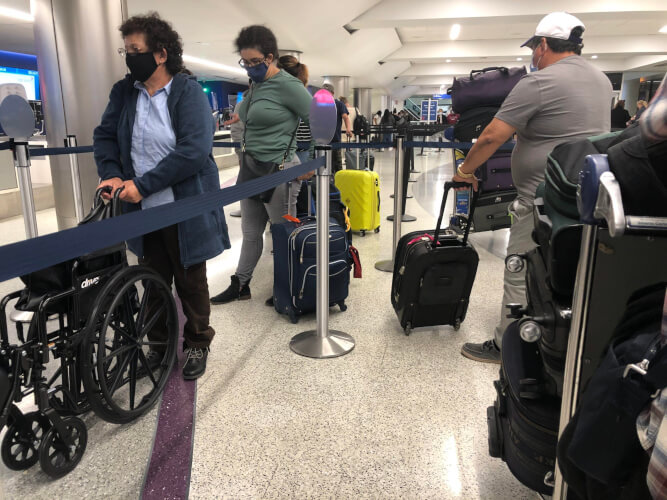 LAX wheelchair being pushed in line