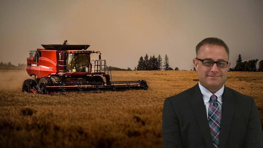 A modern tractor with a sowing machine when planting crops in a rural field  Stock Photo