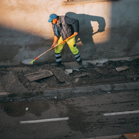 Paver Truck Employee with shovel spreader